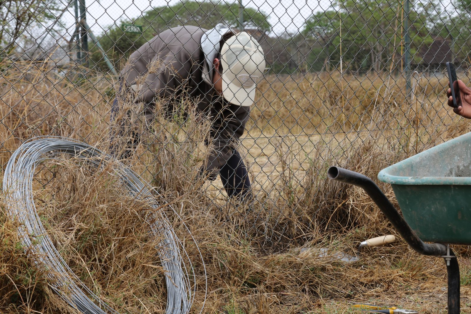 Fence repair: wire and barrow, Zimbabwe